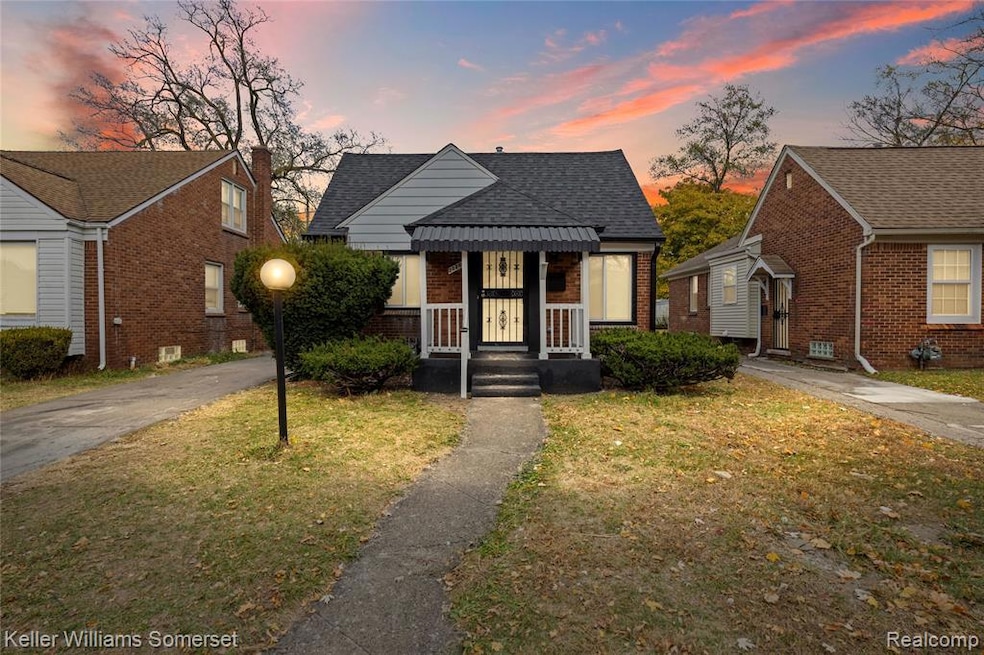 Bungalow-style home with a yard, brick siding, and roof with shingles