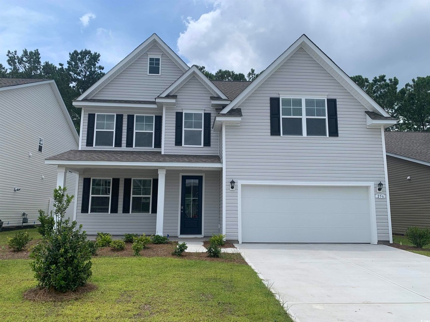 View of front of home with a garage and a front ya