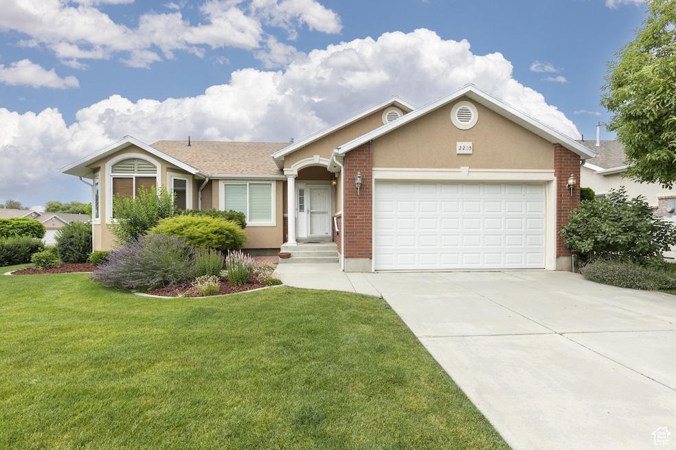 Single story home with driveway, a front lawn, an attached garage, stucco siding, and brick siding