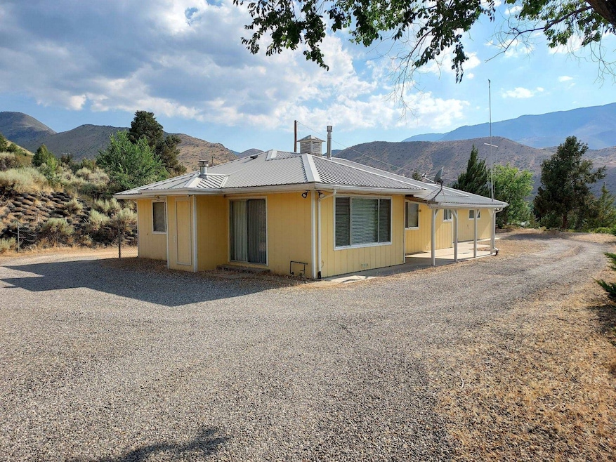 Rear view of property featuring a mountain view, a metal roof, and a chimney