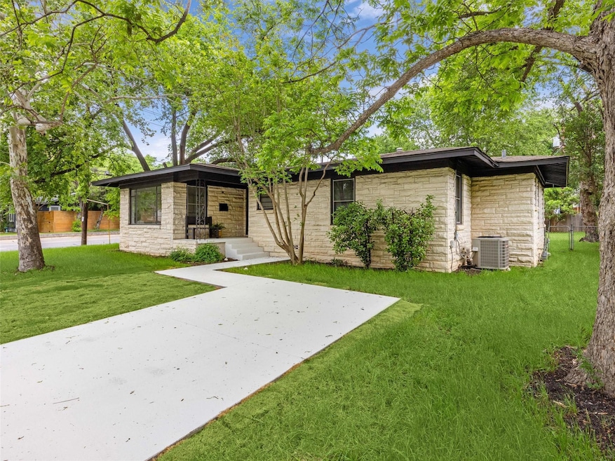 Rear view of house featuring stone siding and a patio