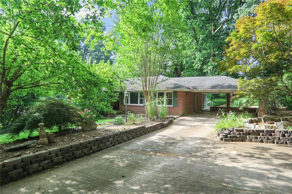 View of front of house with concrete driveway, a carport, and brick siding
