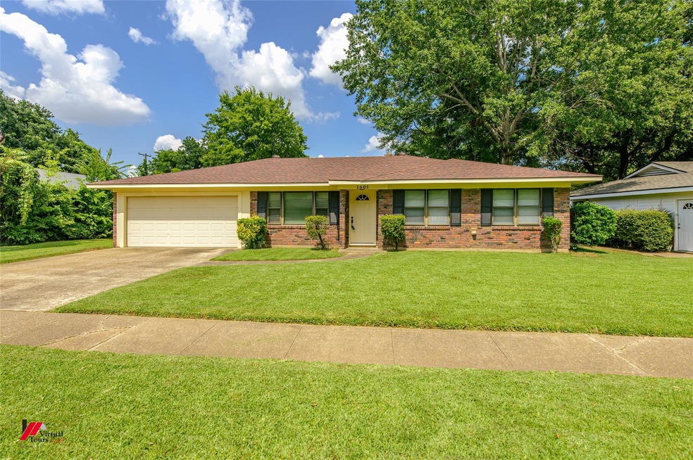 Single story home with a garage and a front lawn