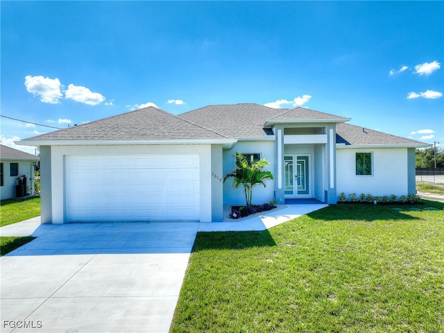 View of front of home with a front yard, stucco siding, driveway, a shingled roof, and a garage