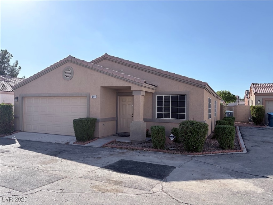 View of front of home featuring stucco siding, a tiled roof, driveway, and an attached garage