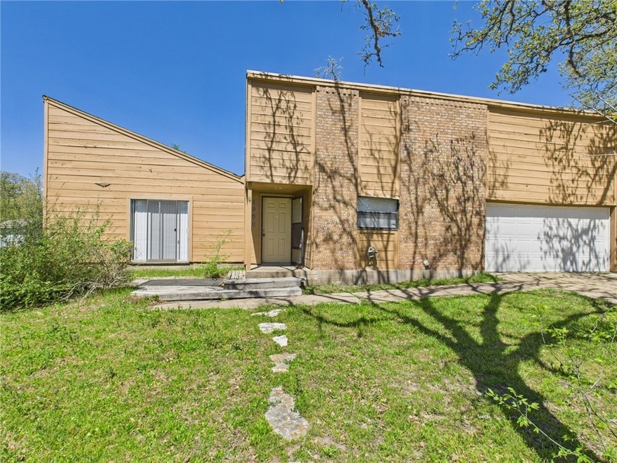 View of front of house with a garage and a front y