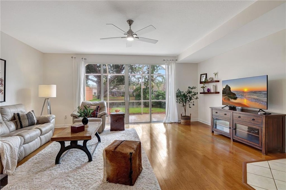 Living room with ceiling fan and light hardwood / 