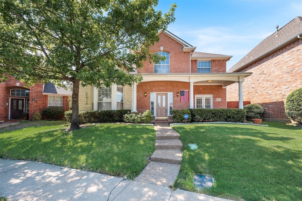 Traditional-style home with brick siding, a front yard, and covered porch