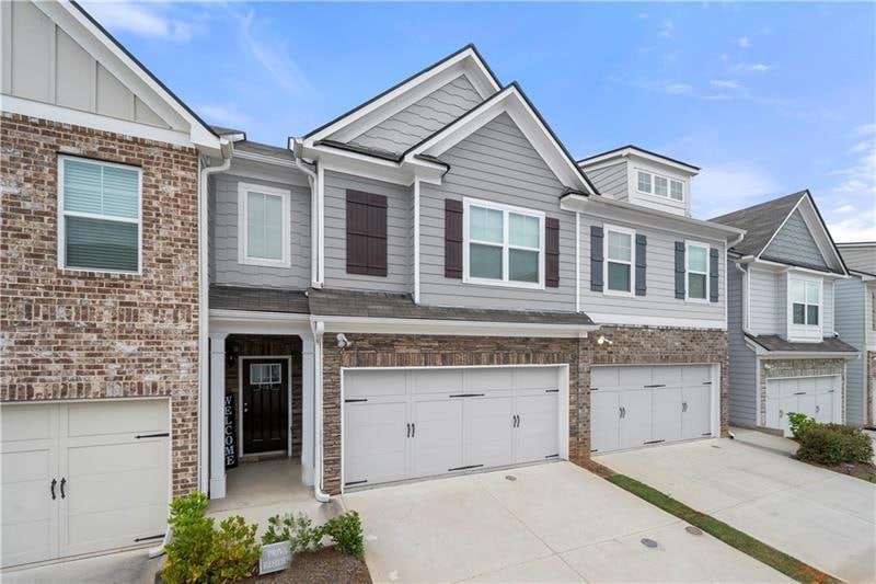 Townhome / multi-family property with a garage, dr