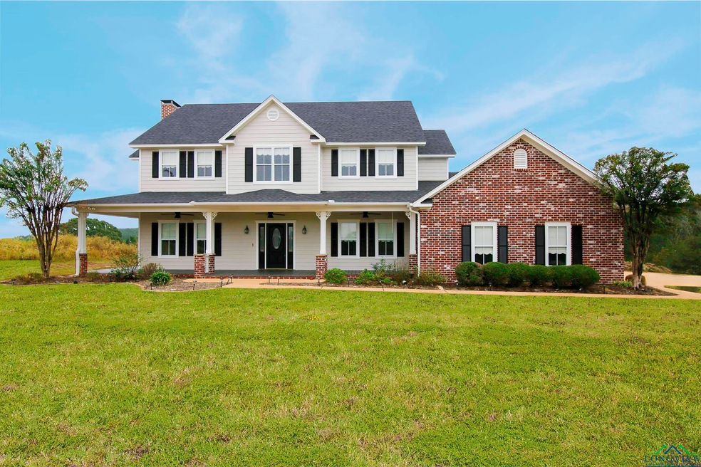 View of front facade featuring a front yard and covered porch