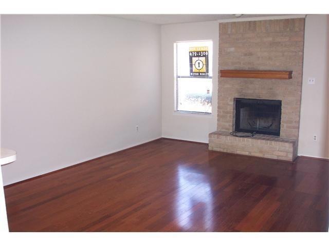 Unfurnished living room with a brick fireplace, w