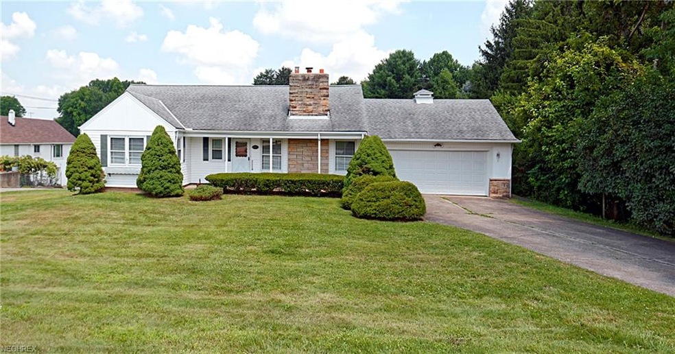 Wide covered porch between the shrubs and living r