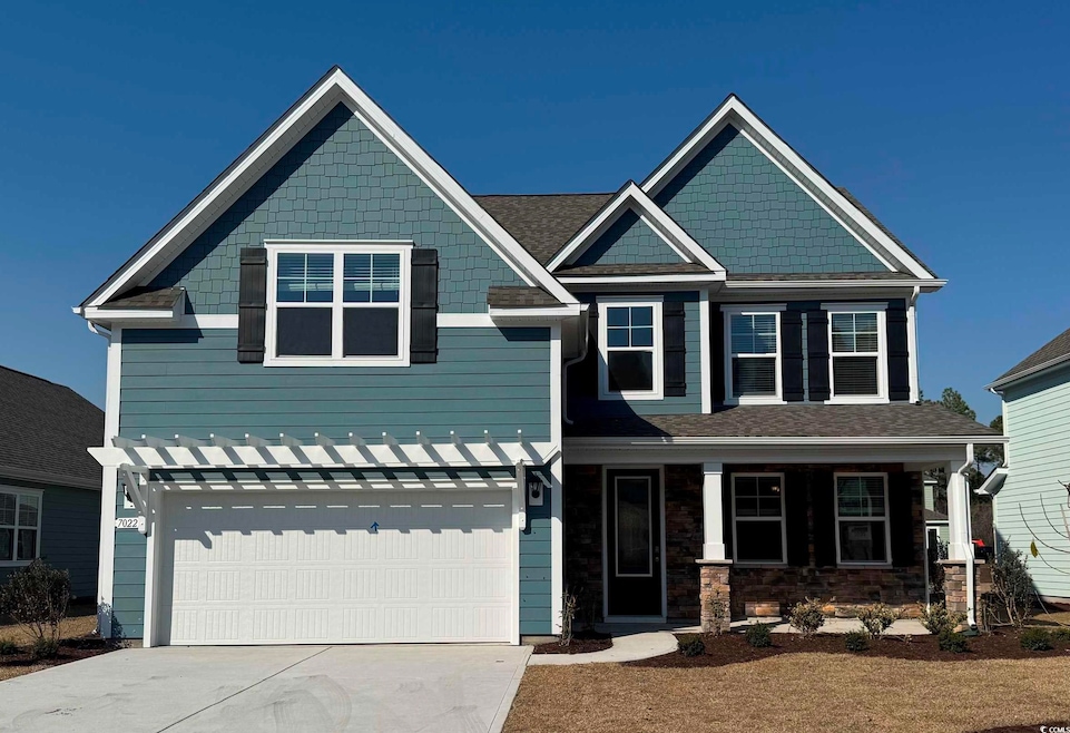 Craftsman-style home featuring a garage and drivew