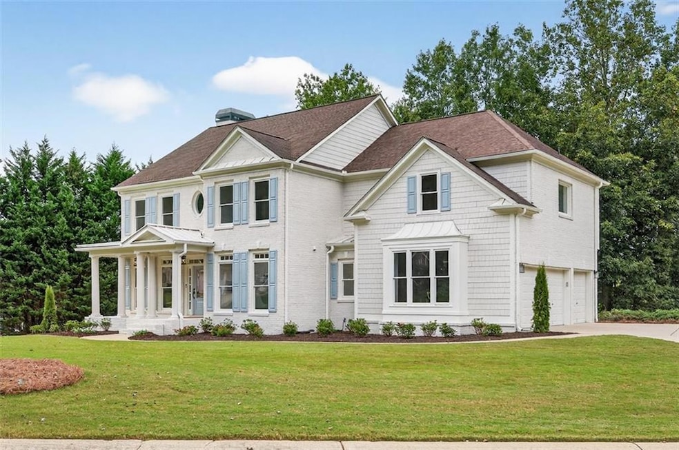 View of front of property with a front yard, driveway, a garage, and roof with shingles