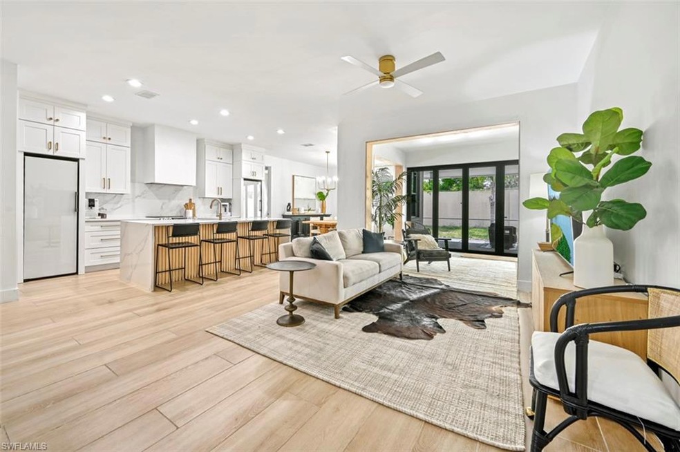 Living area with light wood-type flooring, a ceiling fan, and recessed lighting