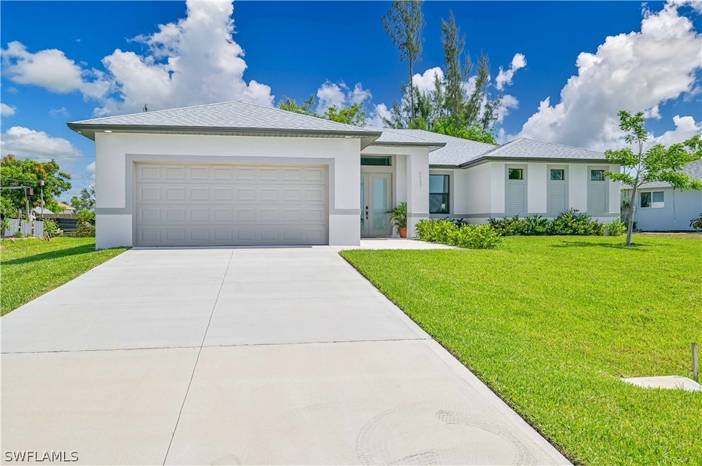 View of front facade with a garage and a front law