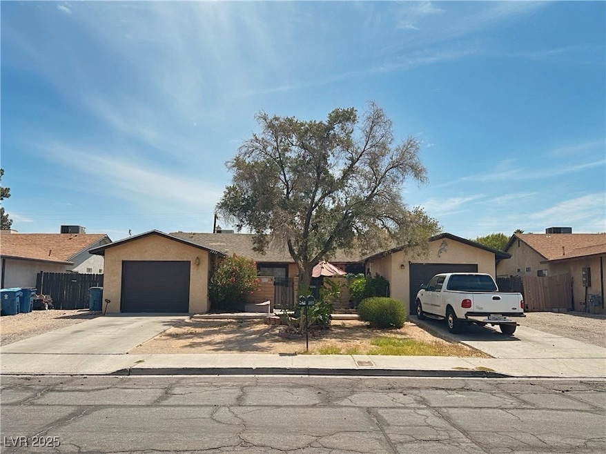 Ranch-style house with stucco siding, driveway, and a garage