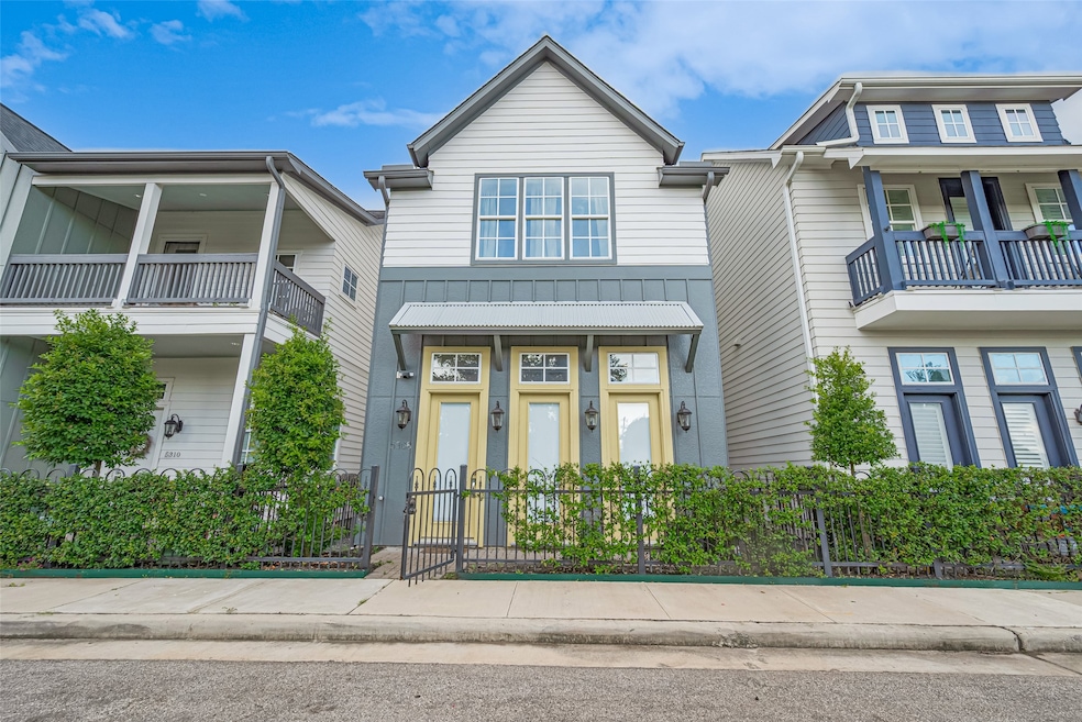 A cheerful facade with soft yellow trim, set behin