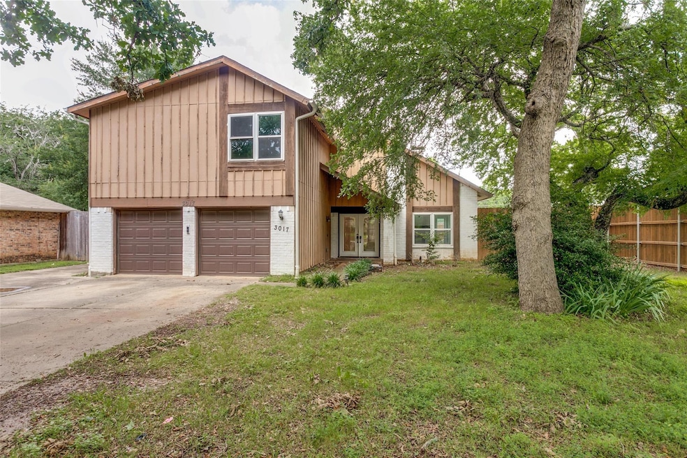 View of front of property with a garage and a front lawn