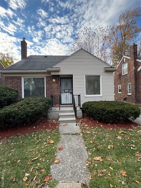 Bungalow-style house featuring a front yard, brick siding, and a shingled roof