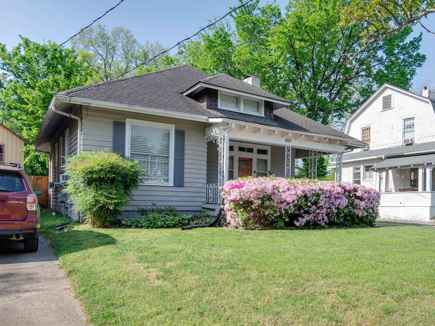 Bungalow-style house featuring a front yard, roof with shingles, and covered porch