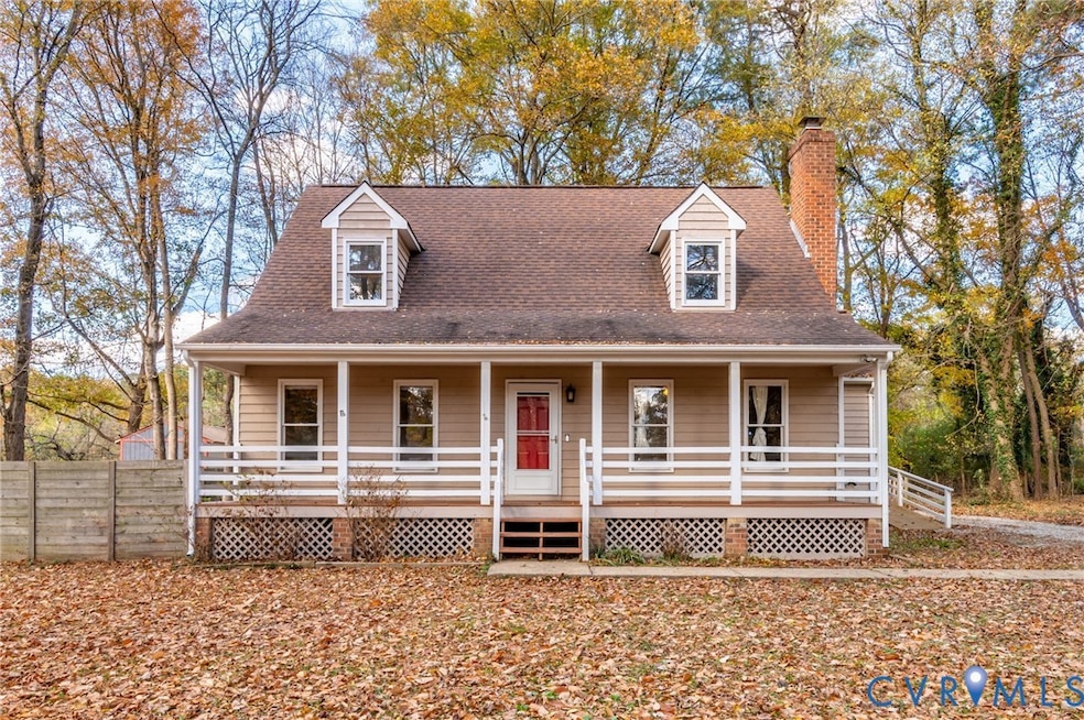 View of front of property with a porch, a shingled roof, and a chimney