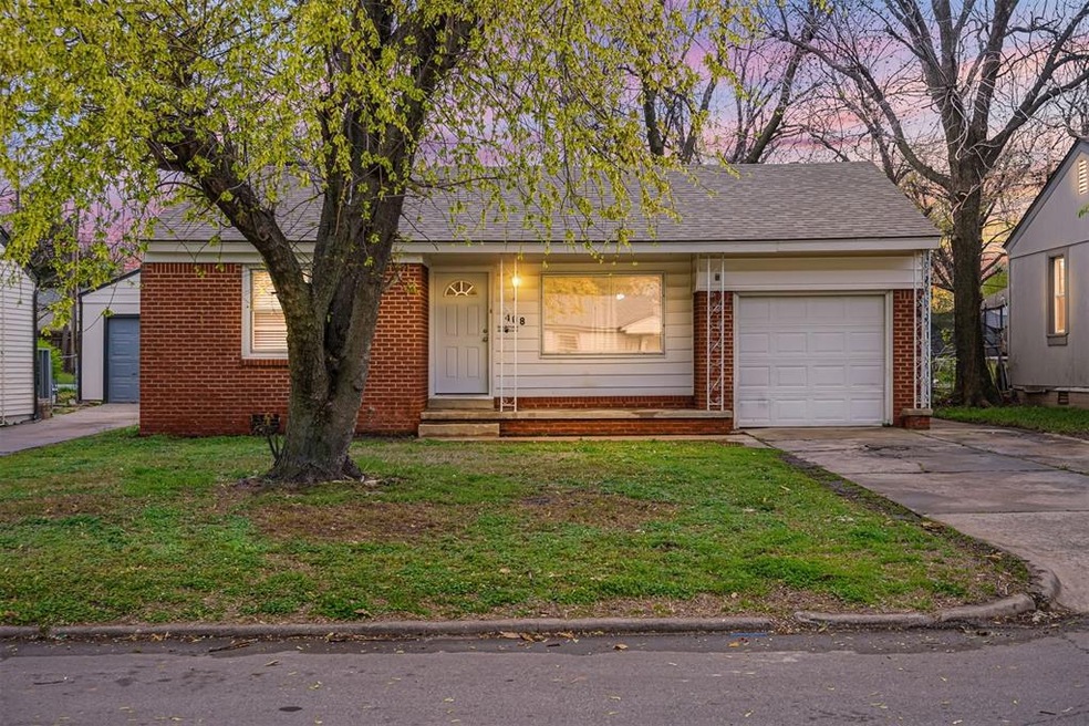 View of front facade featuring a lawn and a garage