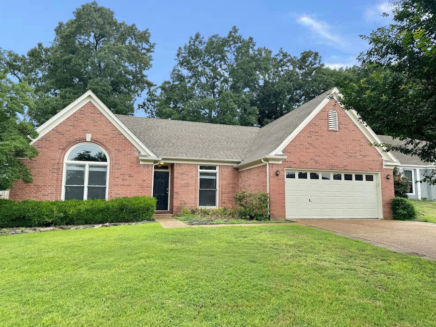 View of front facade with a garage and a front law