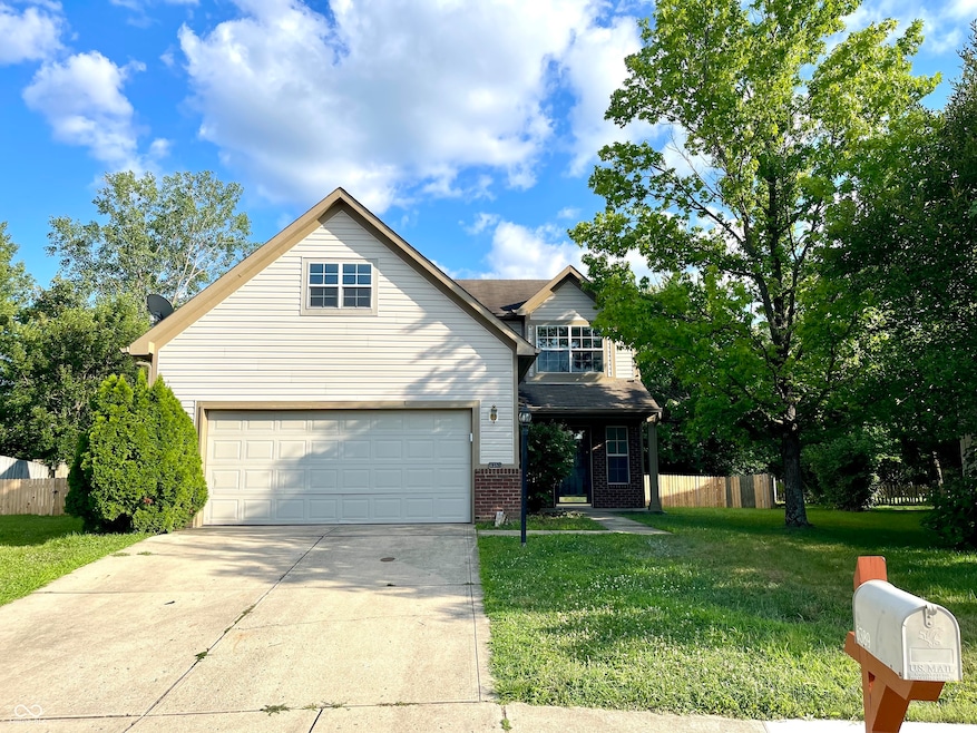 traditional-style house with driveway and brick siding
