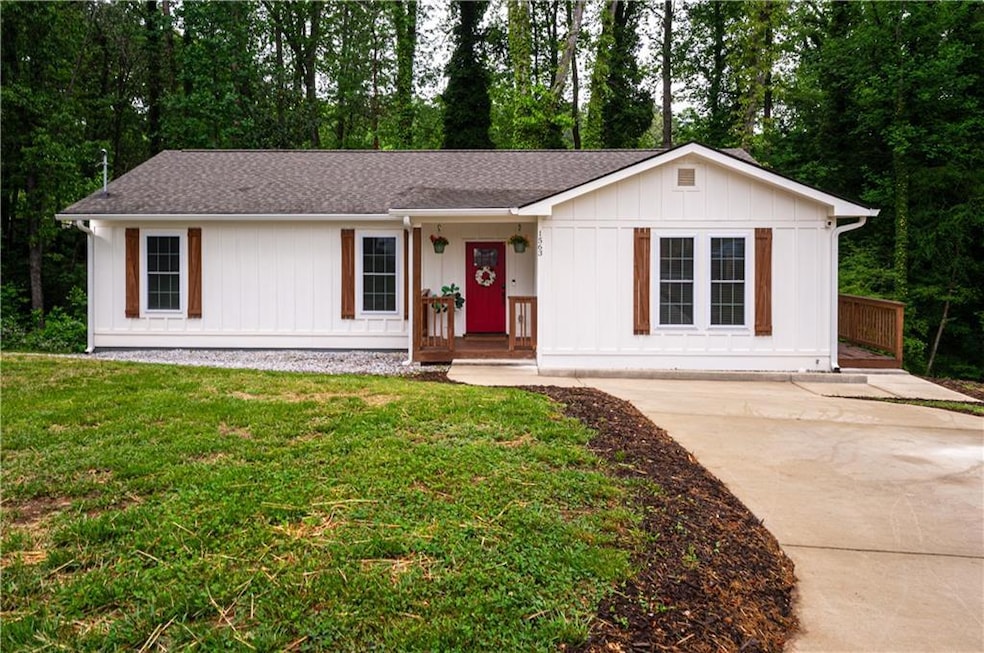 Single story home featuring a shingled roof, board