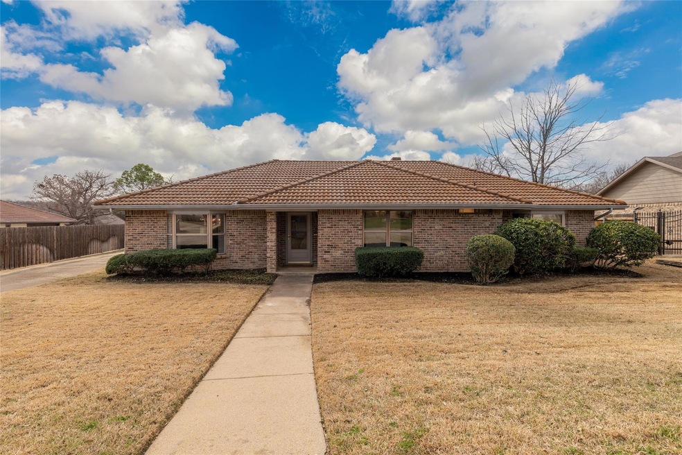 Ranch-style home with a tiled roof, brick siding, 
