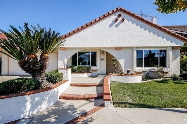 Nicely brick accented entry and planters invite yo