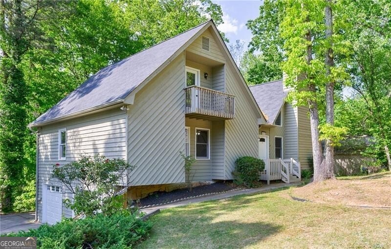 View of front facade with a balcony, driveway, an 
