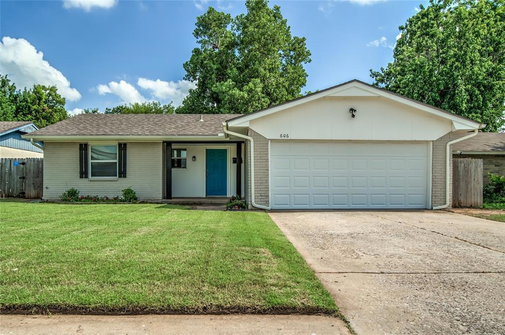 Single story break home featuring concrete driveway, a new garage door, and new roof with gutters