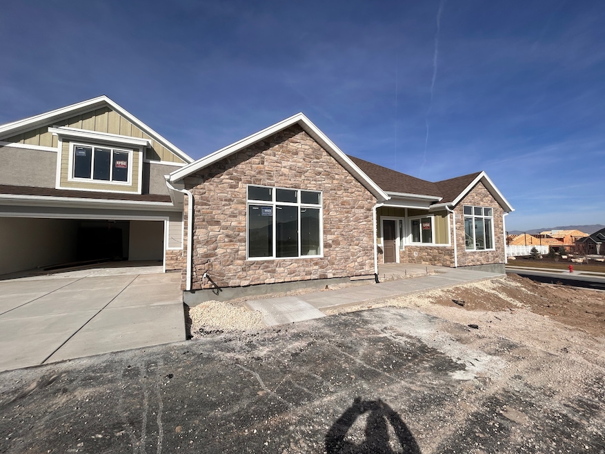 Craftsman house featuring stone siding, driveway, board and batten siding, an attached garage, and covered porch