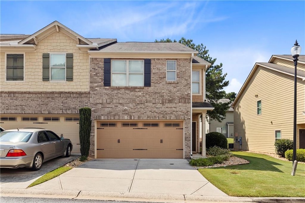 View of front of home with driveway, brick siding, a shingled roof, an attached garage, and a front lawn