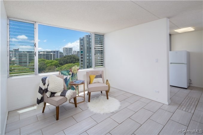 Living room with large window over looks treetops.