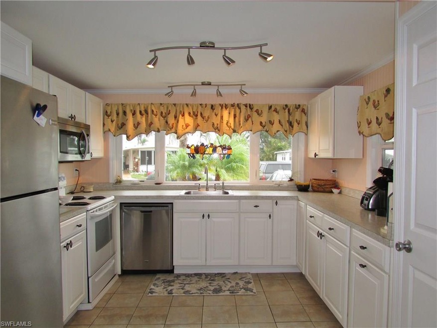 Kitchen with tile floor and stainless steel refrig
