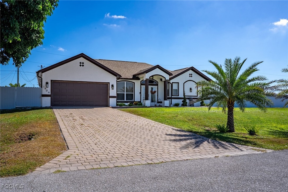 View of front of house with decorative driveway, stucco siding, and an attached garage