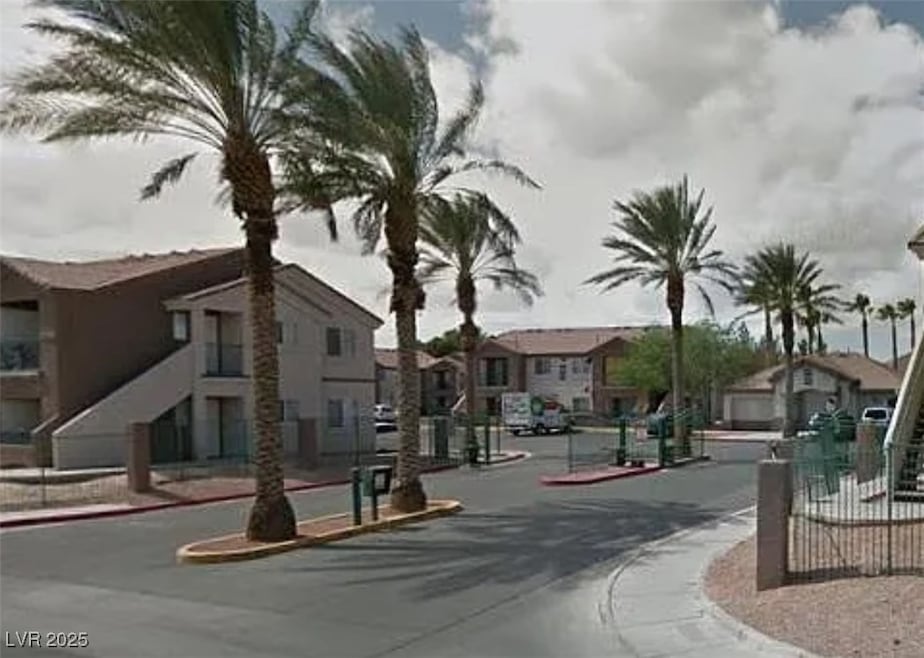 View of asphalt road featuring sidewalks, curbs, a