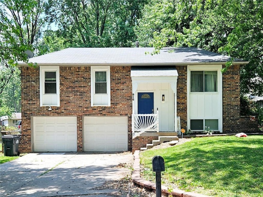Bi-level home with a front yard and a garage