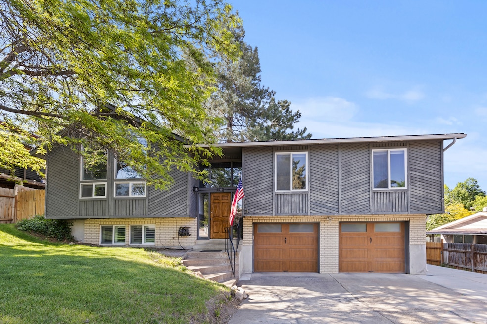 Split foyer home featuring brick siding, driveway, and a garage