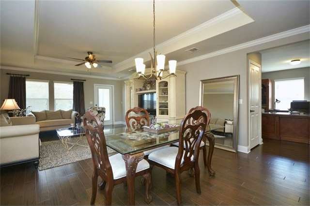 Wood floors span throughout the living area of this wonderful Sun city Texas Gray Myst, where a pop-up ceiling adds lofty appeal at the Great Room.  Wood floors continue into the open Media Room/Office.