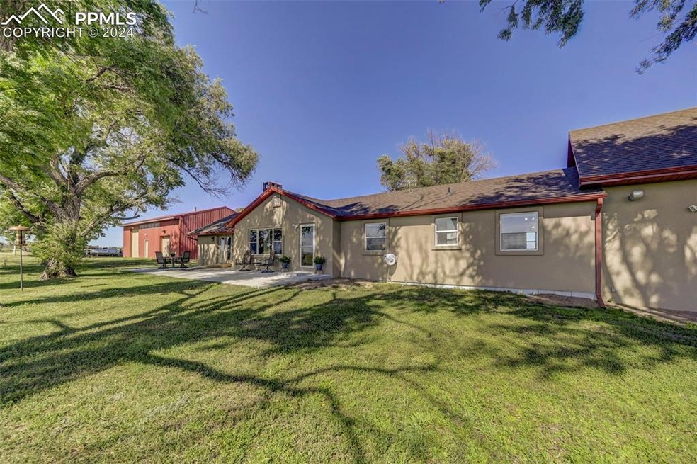 Back of property with a lawn and a patio area