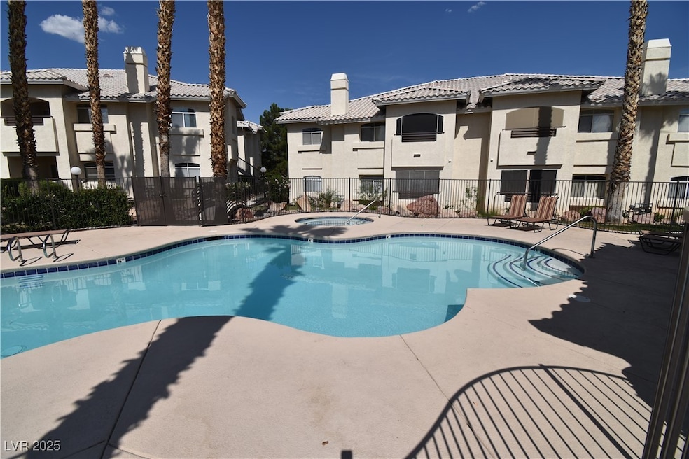 Community pool with a hot tub and a patio area
