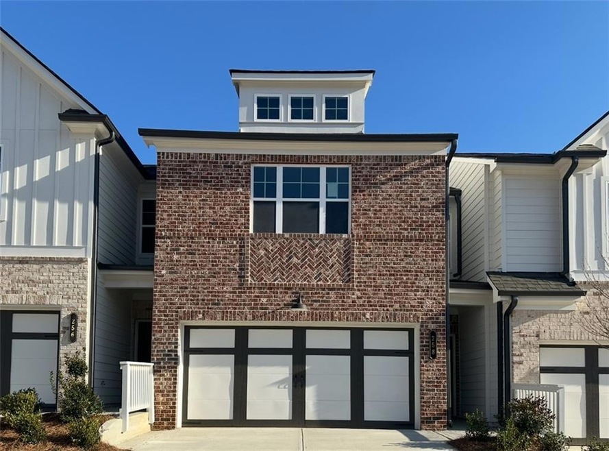 View of front of home with brick siding, driveway,