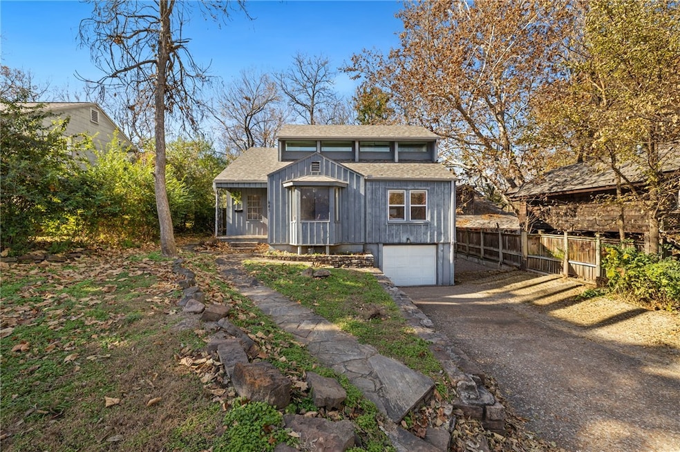 View of front of house featuring roof with shingles, driveway, and an attached garage