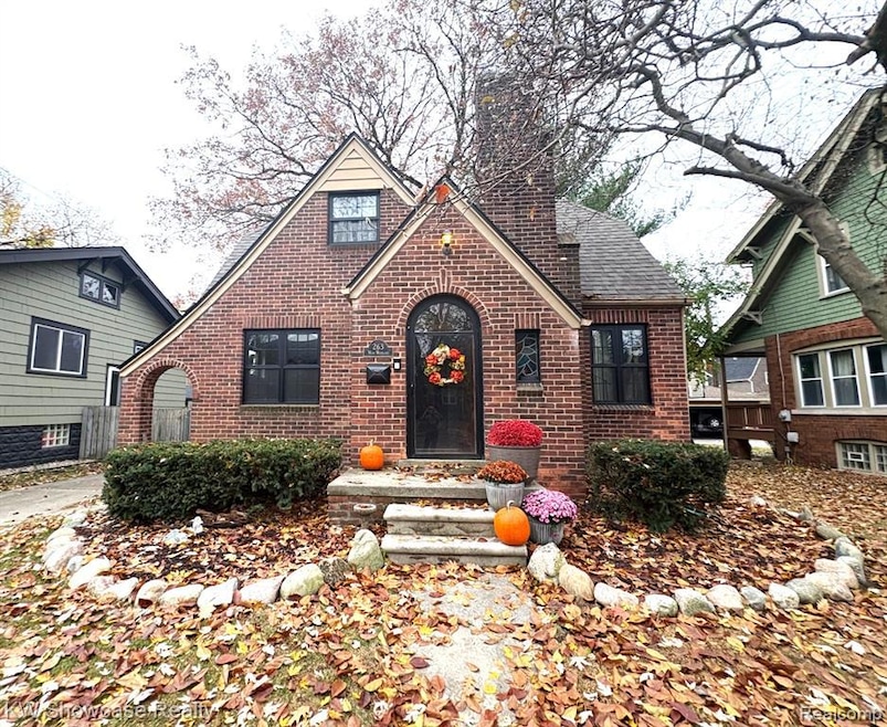 Tudor home featuring brick siding and a chimney