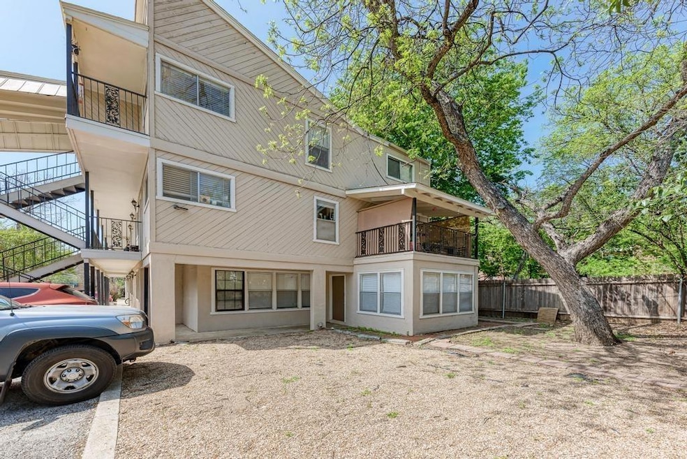 Back of property featuring a balcony, stairs, and