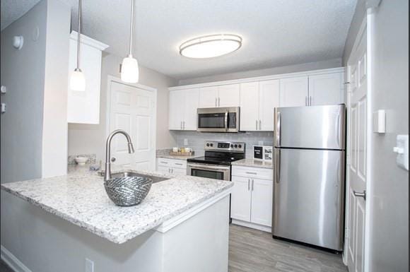 Kitchen featuring kitchen peninsula, white cabinet